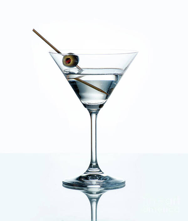 Martini Poster featuring the photograph Dry martini with green olive in cocktail glass over white backgr by Jelena Jovanovic