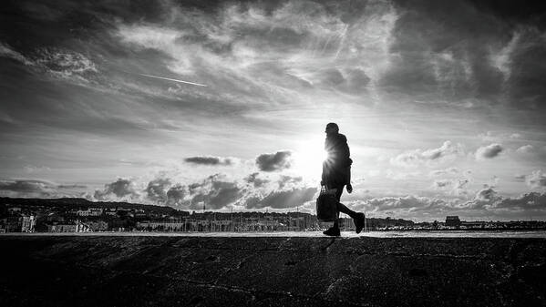 Black And White Poster featuring the photograph A man at sunset - Howth, Ireland - Black and white street photography by Giuseppe Milo