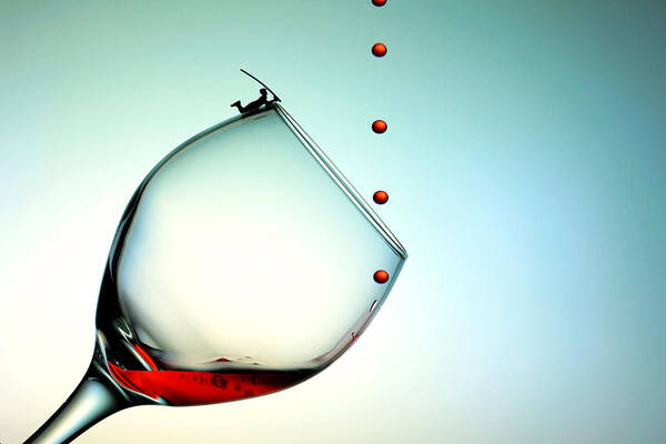 Red Poster featuring the photograph Fishing on a glass cup with red wine droplets little people on food by Paul Ge