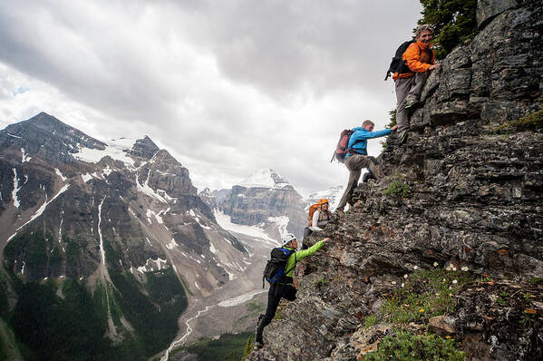 Scenics Poster featuring the photograph Four Mountaineers Ascend Cliff Above by Ascent Xmedia