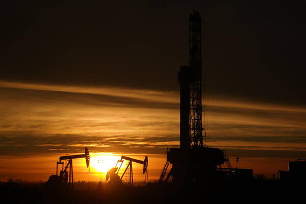 Williston. North Dakota Poster featuring the photograph Oil rig and two pumpjacks in the sunset by Jeff Swan
