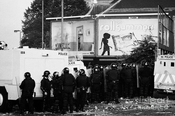 Northern Poster featuring the photograph PSNI riot officers behind armoured land rover water cannon beneath on crumlin road at ardoyne shops by Joe Fox