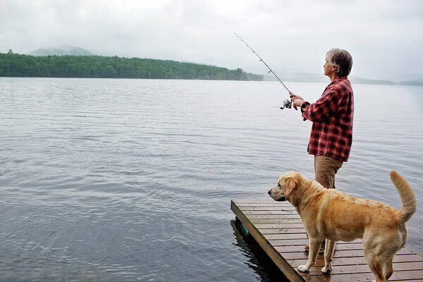 Senior Man Fishing Off Dock With Dog Poster by Monica Donovan