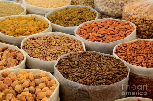 Nuts Poster featuring the photograph Variety of raw nuts for sale at outdoor street market Karachi Pakistan by Imran Ahmed