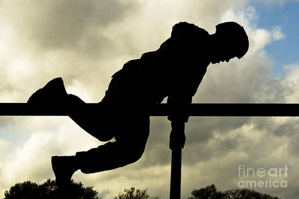 Traversing Poster featuring the photograph An Airman Scales An Obstacle At Camp by Stocktrek Images