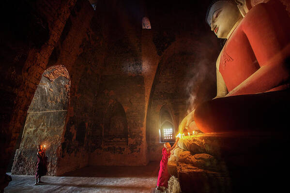 Monk Poster featuring the photograph Monk in Bagan old town pray a buddha statue with candle by Anek Suwannaphoom