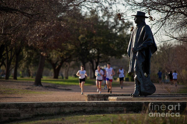 Runners Poster featuring the photograph Runners and joggers pass by the Stevie Ray Vaughan Memorial Statue on Lady Bird Town Lake hike and bike trail by Dan Herron