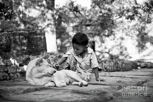2015 Poster featuring the photograph Cambodian boy near some ruins playing with his dog. #1 by Joaquin Corbalan