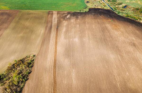 Landscapeaerial Poster featuring the photograph Tractor Plowing Field In Spring #1 by Ryhor Bruyeu