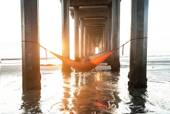 La Jolla Poster featuring the photograph Girls In A Hammock Under A Pier By The Ocean At Sunset In Southe by Cavan Images