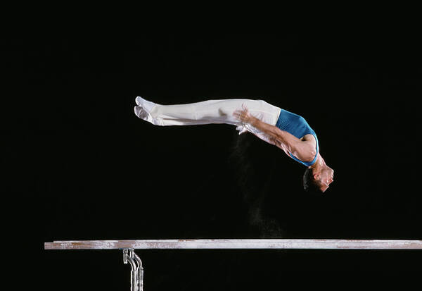 One Man Only Poster featuring the photograph Male Gymnast Performing On Parallel Bars by David Madison