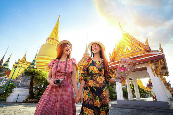 Bangkok Poster featuring the photograph Two asian girlfriends traveling and check location by a map in G by Anek Suwannaphoom