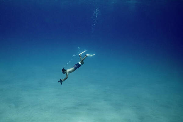 Underwater Photographer Free Diving Deep To Ocean Floor In Hawaii Poster by  Cavan Images - Fine Art America