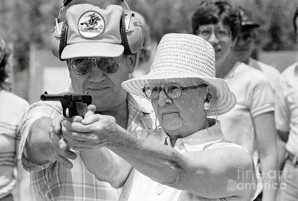1980-1989 Poster featuring the photograph Woman Practicing Firing A Gun by Bettmann