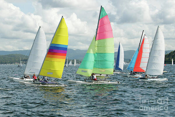 Female Poster featuring the photograph Children Sailing small sailboats with colourful sails on an inla by Geoff Childs