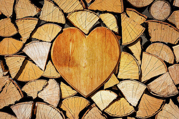 Pile Poster featuring the photograph Stack of firewood with a wooden heart by Bernhard Schaffer
