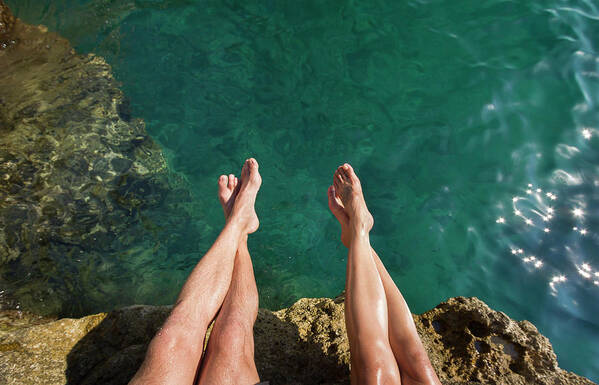 Heterosexual Couple Poster featuring the photograph Couples Legs Above Turquoise Ocean by Picturegarden
