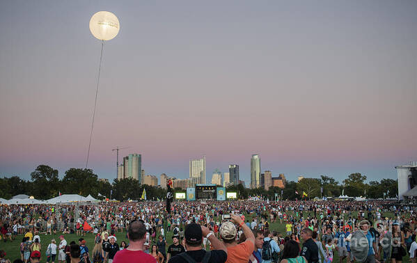 Austin City Limits Poster featuring the photograph A giant ACL helium ballon lights up the night sky during the Austin City Limits Music Festival overlooking the Austin skyline on October 12, 2014. by Dan Herron