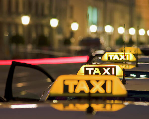 In A Row Poster featuring the photograph Illuminated Taxi Signs by Bernhard Lang