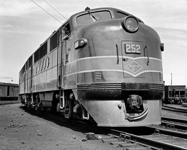 B&w Black And White 1940s 1950s 1939-1945 Adults Alone America American Anonymous Built By Carrier Diesel Electric Electro-motive Division Engineer Engine Exterior Freight Full-length Ggeneral Motors Head On Industry Line Locomotive Logo Low Angle Occupations Outdoors Pa Pennsylvania Powerful Railroad Railway Rail Reading Lines Reading Single Streamline Stylish Suburban Trains Transportation Travel Urban Usa Victory View Window Retro Vintage Nostalgic Old Fashioned Old Fashion Old Time Classic Poster featuring the photograph 1940s head on reading lines diesel electric railroad engine model EMD FT built by General Motors by Panoramic Images