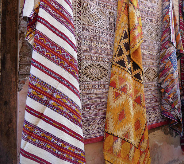 Bright Colored Poster featuring the photograph Bright colored patterns on throw rugs in the medina bazaar by Steve Estvanik