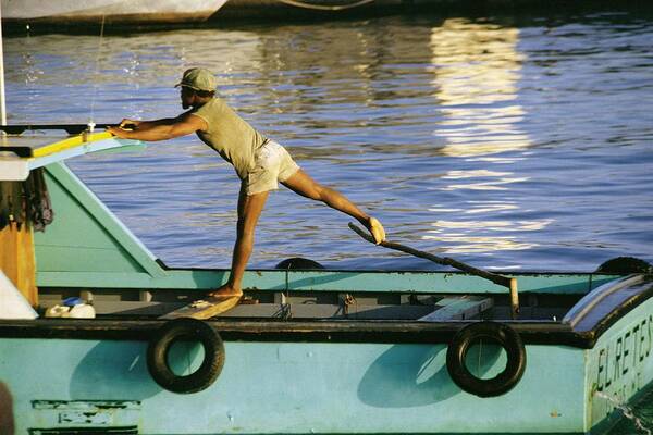 Barbados West-indies Bridgetown Fisherman Launch Helmsman Anchorage Fishing Art Print featuring the photograph Boatman by Ronald Griffith