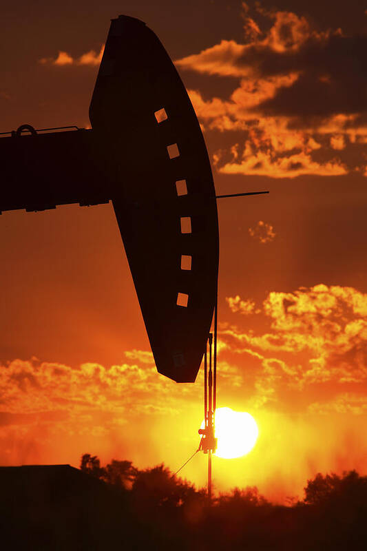 Oil Rig Art Print featuring the photograph Oil rig pump jack silhouetted by setting sun #1 by Mark Duffy