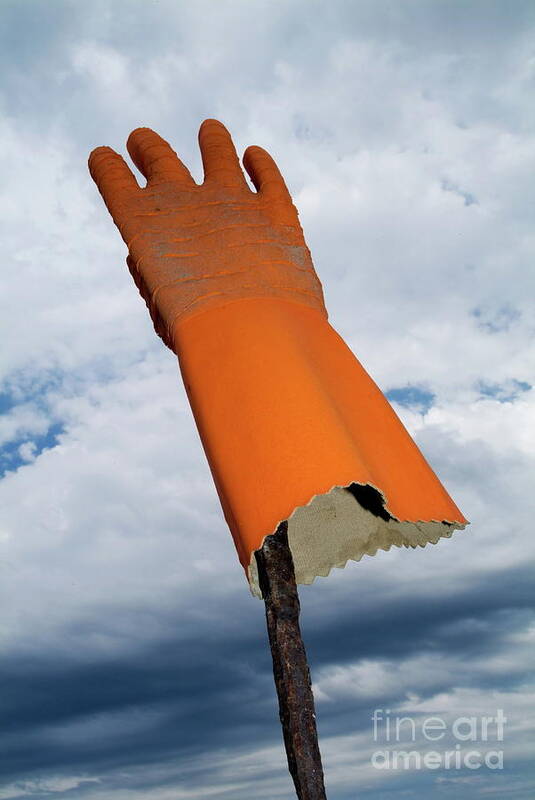 Bizarre Art Print featuring the photograph Orange rubber glove on a wooden post against a cloudy sky by Sami Sarkis