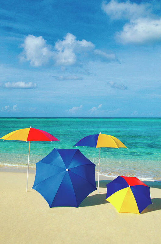 Recreational Pursuit Art Print featuring the photograph Four Umbrellas On The Smooth Sands Of by Medioimages/photodisc