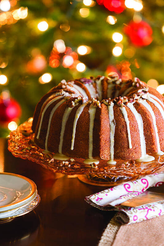 Bundt Cake Art Print featuring the photograph High Angle View Of Chocolate Bundt Cake On Cakestand Against Illuminated Christmas Tree At Home by Cavan Images