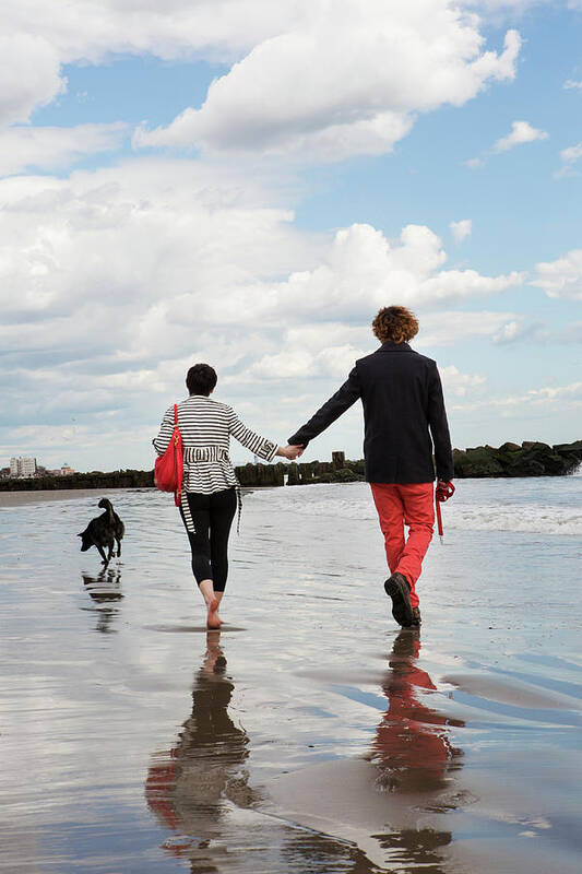 Couple Art Print featuring the photograph Rear View Of Couple Holding Hands While Walking On Shore At Beach by Cavan Images