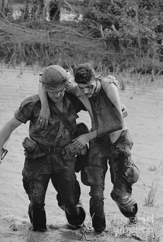 Vietnam War Art Print featuring the photograph Soldier Helping Wounded Soldier by Bettmann