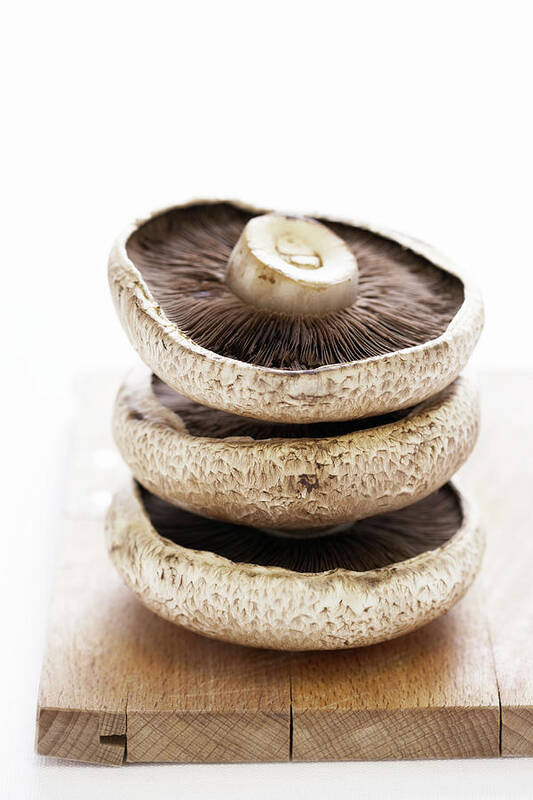 White Background Art Print featuring the photograph Three Flat Mushrooms In Pile On Wooden by Martin Poole