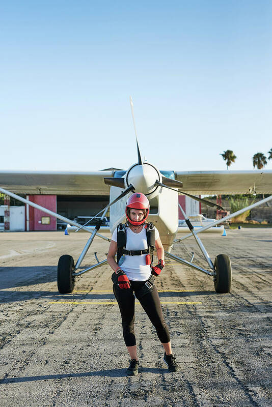 Skydivers Art Print featuring the photograph Young Female Skydiver In An Airfield With Plane In The Back by Cavan Images