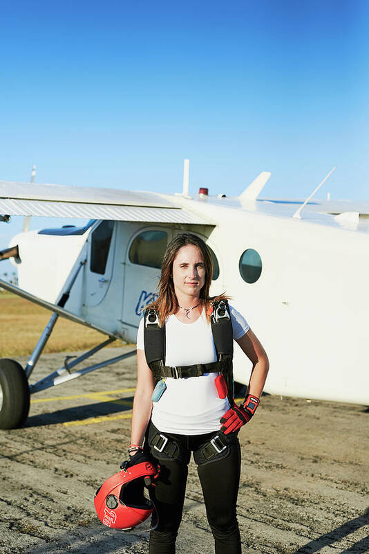 Skydivers Art Print featuring the photograph Young Female Skydiver With Backpack In An Airfield With Plane by Cavan Images