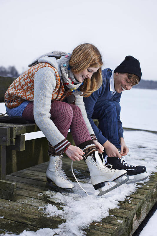 Young Men Art Print featuring the photograph Couple ice skating on lake by Niels Busch
