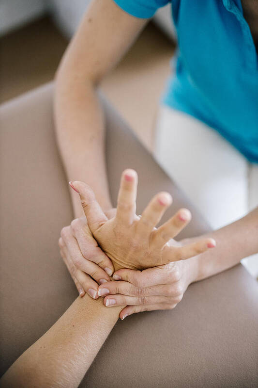 Expertise Art Print featuring the photograph Female physiotherapist giving patient a hand massage, close up by Westend61