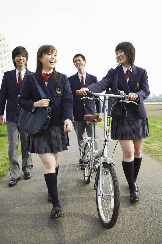 Education Art Print featuring the photograph Four Students in Uniform Walking Outdoors, One Holding a Bicycle by Digital Vision.