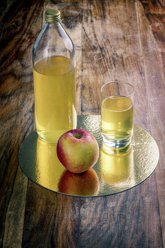 Drinking Glass Art Print featuring the photograph Fresh apple juice and red apple on a rustic wooden table by Benoit Bruchez