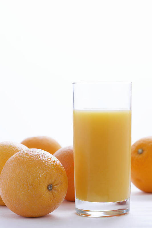White Background Art Print featuring the photograph Whole oranges by orange juice in glass, close-up by Martin Poole