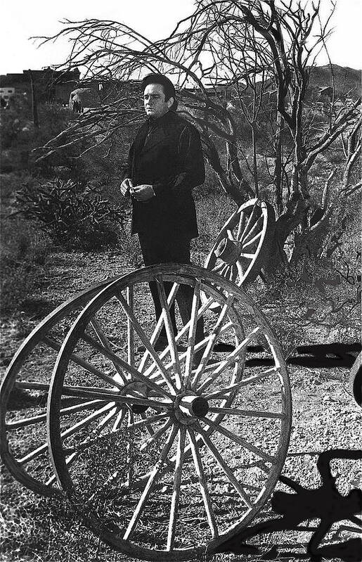 Johnny Cash Meditating Wagon Wheel Graveyard Old Tucson Az Black And White Art Print featuring the photograph Johnny Cash meditating wagon wheel graveyard Old Tucson Arizona 1971 by David Lee Guss