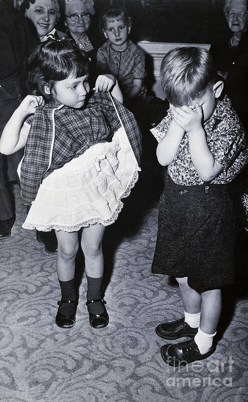 Confusion Art Print featuring the photograph Boy Covering Eyes As Girl Raises Skirt by Bettmann