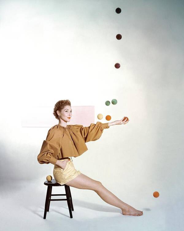 Juggling Art Print featuring the photograph A Model Sitting On A Stool Juggling by John Rawlings