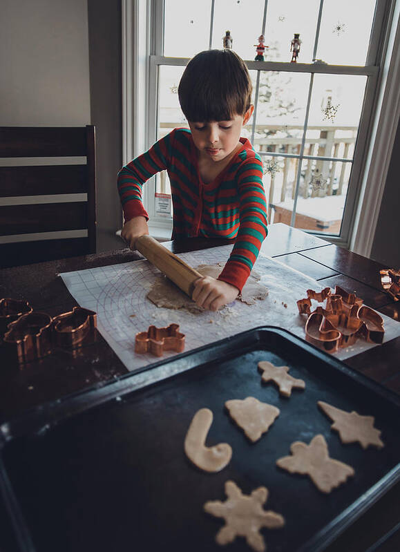 Boy Art Print featuring the photograph Boy Rolling Cookie Dough On Table During Christmas At Home by Cavan Images