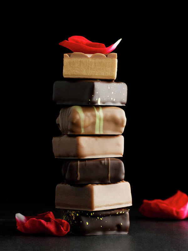 Black Background Art Print featuring the photograph Tower Of Chocolates With Rose Petals On by Sabine Scheckel