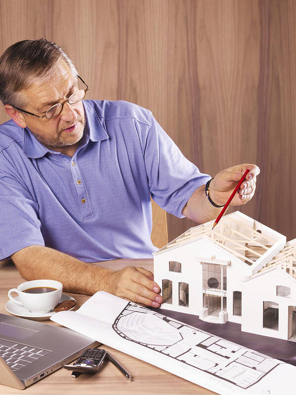 Holding Art Print featuring the photograph Architect with model house on desk by Peter Dazeley