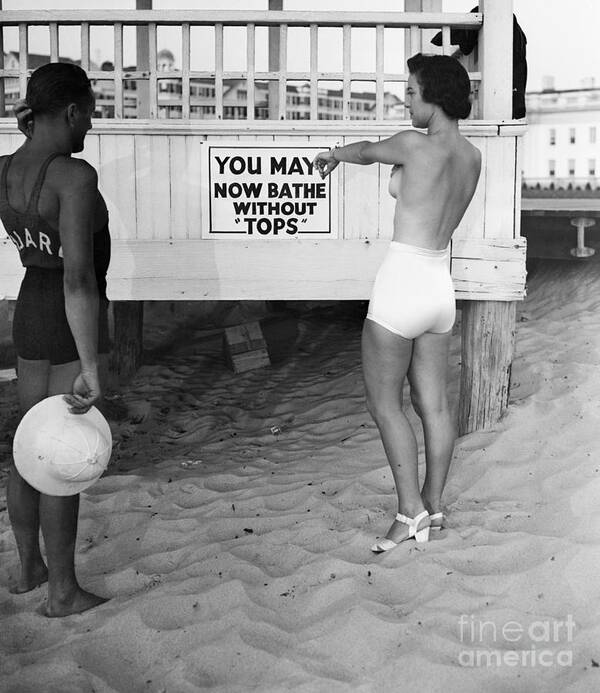 Confusion Art Print featuring the photograph Topless Bather Pointing To Sign On Beach by Bettmann