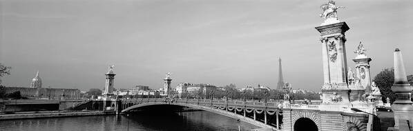 Alexandre Iii Bridge Arch Bridge Building Exterior Building Structure Cloud Black And White Day Eiffel Tower Europe France Horizontal Mediterranean Countries Nobody Outdoors Panoramic Paris Photography River Sky Structure Tower Water Architecture Capital Cities City Location Travel Destinations Art Print featuring the photograph Bridge over a river, Alexandre III Bridge, Eiffel Tower, Paris, France by Panoramic Images