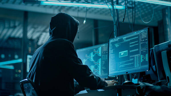 Internet Art Print featuring the photograph Shot from the Back to Hooded Hacker Breaking into Corporate Data Servers from His Underground Hideout. Place Has Dark Atmosphere, Multiple Displays, Cables Everywhere. by Gorodenkoff