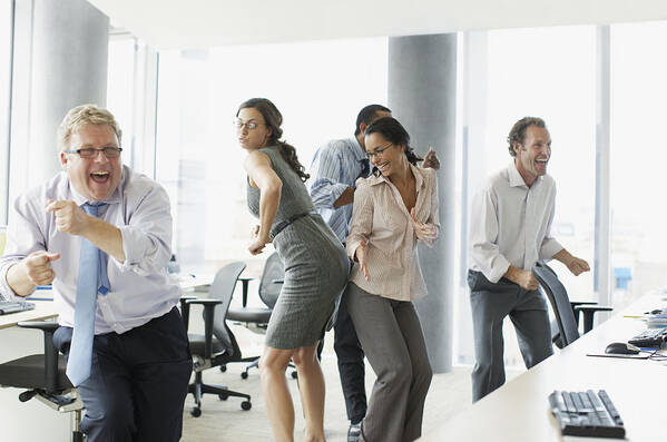 Working Art Print featuring the photograph Businesspeople dancing in office #1 by Paul Bradbury